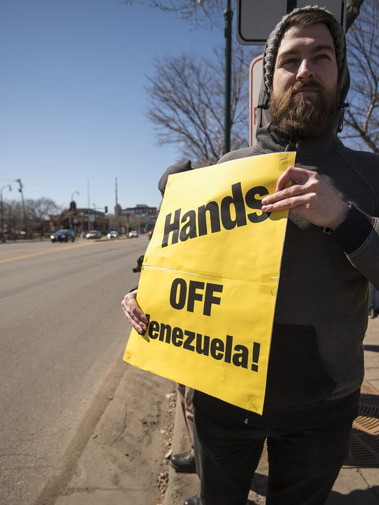 Protester holds sign opposing US intervention in Venezuela